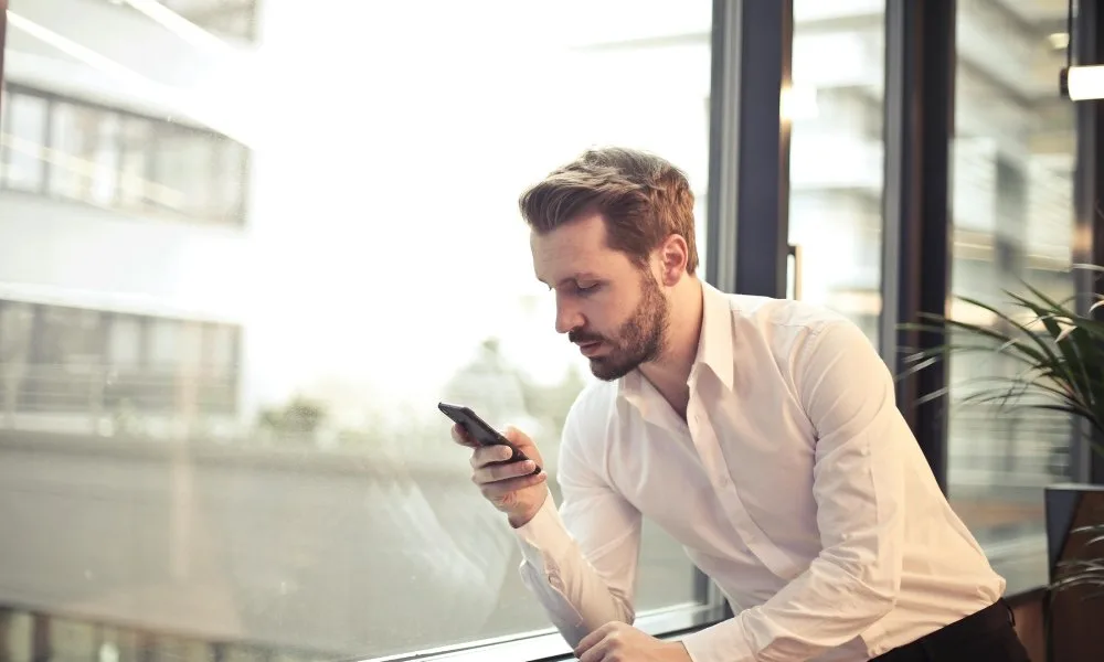 Chef d’entreprise consultant son téléphone au bureau